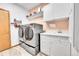 Functional laundry room with modern washer and dryer and white cabinets at 3794 N State Highway 67, Sedalia, CO 80135
