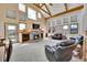 Spacious living room boasts a stone fireplace, large windows, and vaulted ceilings with exposed beams at 3794 N State Highway 67, Sedalia, CO 80135