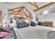 Open living room with vaulted ceilings and exposed beams transitions to the kitchen and dining areas at 3794 N State Highway 67, Sedalia, CO 80135