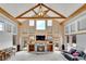 Open living room features a stone fireplace, high ceilings with wood beams and many windows for natural light at 3794 N State Highway 67, Sedalia, CO 80135