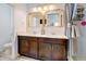 Modern bathroom featuring double sinks, dark wood cabinetry, and stylish fixtures at 9667 Walden St, Commerce City, CO 80022