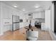 Contemporary kitchen with stainless appliances, white cabinets, and light hardwood flooring at 1750 Wewatta St # 830, Denver, CO 80202