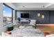Modern living room featuring stylish seating, dark accent wall, and views of the city from the adjacent window at 1750 Wewatta St # 830, Denver, CO 80202