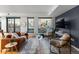 A modern living room with large windows offering breathtaking city views and contemporary furnishings, creates a cozy atmosphere at 1750 Wewatta St # 830, Denver, CO 80202