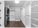 Organized walk-in closet with custom shelving, hanging rods, and a convenient stacked washer and dryer unit at 1750 Wewatta St # 830, Denver, CO 80202