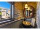 Unique powder room featuring a stone sink, decorative mirror, and accent lighting at 85 Uncle Sam Lode, Breckenridge, CO 80424