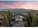 Aerial view of mountainside home surrounded by tall pine trees with scenic mountain backdrop at sunset at 85 Uncle Sam Lode, Breckenridge, CO 80424