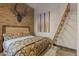 Comfortable bedroom featuring a brick wall, wooden ladder and floral bedding at 85 Uncle Sam Lode, Breckenridge, CO 80424