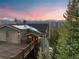 Exterior view of a mountain home featuring a large deck with snow-capped mountains in the background at sunset at 85 Uncle Sam Lode, Breckenridge, CO 80424