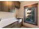 Well-appointed mudroom with custom cabinets, stainless sink, and ample counter space by a window at 85 Uncle Sam Lode, Breckenridge, CO 80424