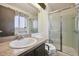 A well-lit bathroom features a walk-in shower, grab bars, and a marble countertop sink at 10475 Tancred St, Northglenn, CO 80234