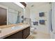 Bright bathroom features a large mirror, wood cabinets and decorative towel racks at 10475 Tancred St, Northglenn, CO 80234