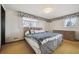 Cozy bedroom featuring a large bed, two windows and an oversized dresser at 10475 Tancred St, Northglenn, CO 80234