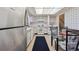 Bright kitchen with white cabinets, stainless steel refrigerator and a dining table near the window at 10475 Tancred St, Northglenn, CO 80234