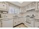 Functional kitchen featuring white appliances, classic white cabinetry, and a practical layout at 10475 Tancred St, Northglenn, CO 80234