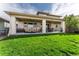 Inviting backyard features a covered patio with lounge seating, hot tub, and well-manicured lawn at 19429 W 88Th Dr, Arvada, CO 80007