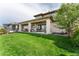 Expansive backyard with lush green lawn, covered patio, and well-maintained landscaping at 19429 W 88Th Dr, Arvada, CO 80007