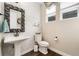 The charming half bathroom features decorative tile and a pedestal sink with a dark wood floor at 19429 W 88Th Dr, Arvada, CO 80007