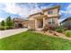Beautiful two-story home with a lush green lawn, stone accents, and an inviting covered front entrance at 19429 W 88Th Dr, Arvada, CO 80007