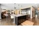 The bright kitchen boasts an island with seating and stainless appliances open to the living area at 19429 W 88Th Dr, Arvada, CO 80007