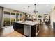 The luxurious kitchen features an island with seating and overlooks the great room and backyard at 19429 W 88Th Dr, Arvada, CO 80007