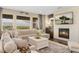 Cozy living room with fireplace, hardwood floors, and large windows at 19429 W 88Th Dr, Arvada, CO 80007