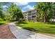 Beautiful Heather Gardens condo with mature trees, green grass and a sidewalk on a sunny day at 3082 S Wheeling Way # 202, Aurora, CO 80014