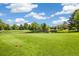 Picturesque golf course featuring a pond, mature trees, green grass, and blue skies at 3082 S Wheeling Way # 202, Aurora, CO 80014