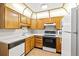 Functional kitchen with wood cabinetry, white countertops, and essential appliances at 3082 S Wheeling Way # 202, Aurora, CO 80014