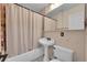 Compact bathroom featuring a pedestal sink, toilet, and a bathtub with a shower curtain at 3450 W Amherst Ave, Denver, CO 80236