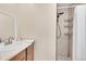 Modern bathroom featuring a stylish shower with glass doors, new faucet, and wood cabinets at 3450 W Amherst Ave, Denver, CO 80236