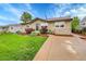 Inviting home featuring a stone facade, tidy landscaping, and a concrete driveway leading to the entrance at 3450 W Amherst Ave, Denver, CO 80236