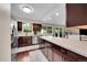 Open kitchen layout with an island and dark wood cabinets with stainless steel appliances and ample natural light at 3450 W Amherst Ave, Denver, CO 80236