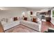 Bright and airy living room with a large white sectional couch and hardwood floors visible from the kitchen at 3450 W Amherst Ave, Denver, CO 80236