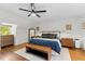 Bright bedroom featuring a ceiling fan, hardwood floors, and a comfortable queen-sized bed with stylish decor at 400 Holly St, Denver, CO 80220