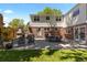 Spacious patio with outdoor dining area, brick fireplace, and lush green lawn, perfect for entertaining at 400 Holly St, Denver, CO 80220
