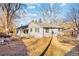 View of the backyard with a cozy patio area and mature trees on a sunny day at 4145 Dudley St, Wheat Ridge, CO 80033