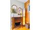Stylish entryway area with mirrors, wooden furniture, designer lighting, and shelving for bar accessories at 4145 Dudley St, Wheat Ridge, CO 80033