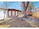 Exterior view of home with a curved stone patio, a red umbrella and comfortable outdoor seating at 4145 Dudley St, Wheat Ridge, CO 80033