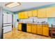 Modern kitchen design featuring tan cabinets, black appliances, and tile floor at 4145 Dudley St, Wheat Ridge, CO 80033