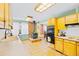 Open kitchen and dining area with wood-burning stove, and vintage cabinets at 4145 Dudley St, Wheat Ridge, CO 80033