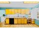 Bright kitchen featuring wooden cabinets, a white sink, and tile flooring at 4145 Dudley St, Wheat Ridge, CO 80033
