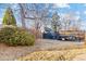 Backyard with a storage shed and wood trailer behind a wooden fence surrounded by trees and bushes at 4145 Dudley St, Wheat Ridge, CO 80033