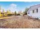 Spacious front yard featuring mature trees, lush shrubs, and a charming fence at 4145 Dudley St, Wheat Ridge, CO 80033
