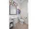Bright half bathroom featuring a pedestal sink, decorative mirror, and fresh paint at 4830 Monarch Dr, Firestone, CO 80504