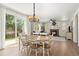 Charming dining area with a chandelier and an adjacent living room featuring a brick fireplace and backyard views at 4830 Monarch Dr, Firestone, CO 80504