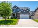 Charming two-story home showcasing a well-manicured lawn, attached two car garage, and a welcoming, covered front porch at 4830 Monarch Dr, Firestone, CO 80504