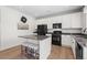 Well-equipped kitchen featuring white cabinets, stainless steel appliances, and a granite-topped kitchen island with barstools at 4830 Monarch Dr, Firestone, CO 80504