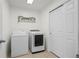 Functional laundry room with washer, dryer, shelving, and closet at 4830 Monarch Dr, Firestone, CO 80504