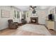 Inviting living room featuring a brick fireplace, comfortable seating, and ample natural light from large windows at 4830 Monarch Dr, Firestone, CO 80504